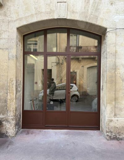 Façade de commerce avec grille métallique artisanale et porte en acier