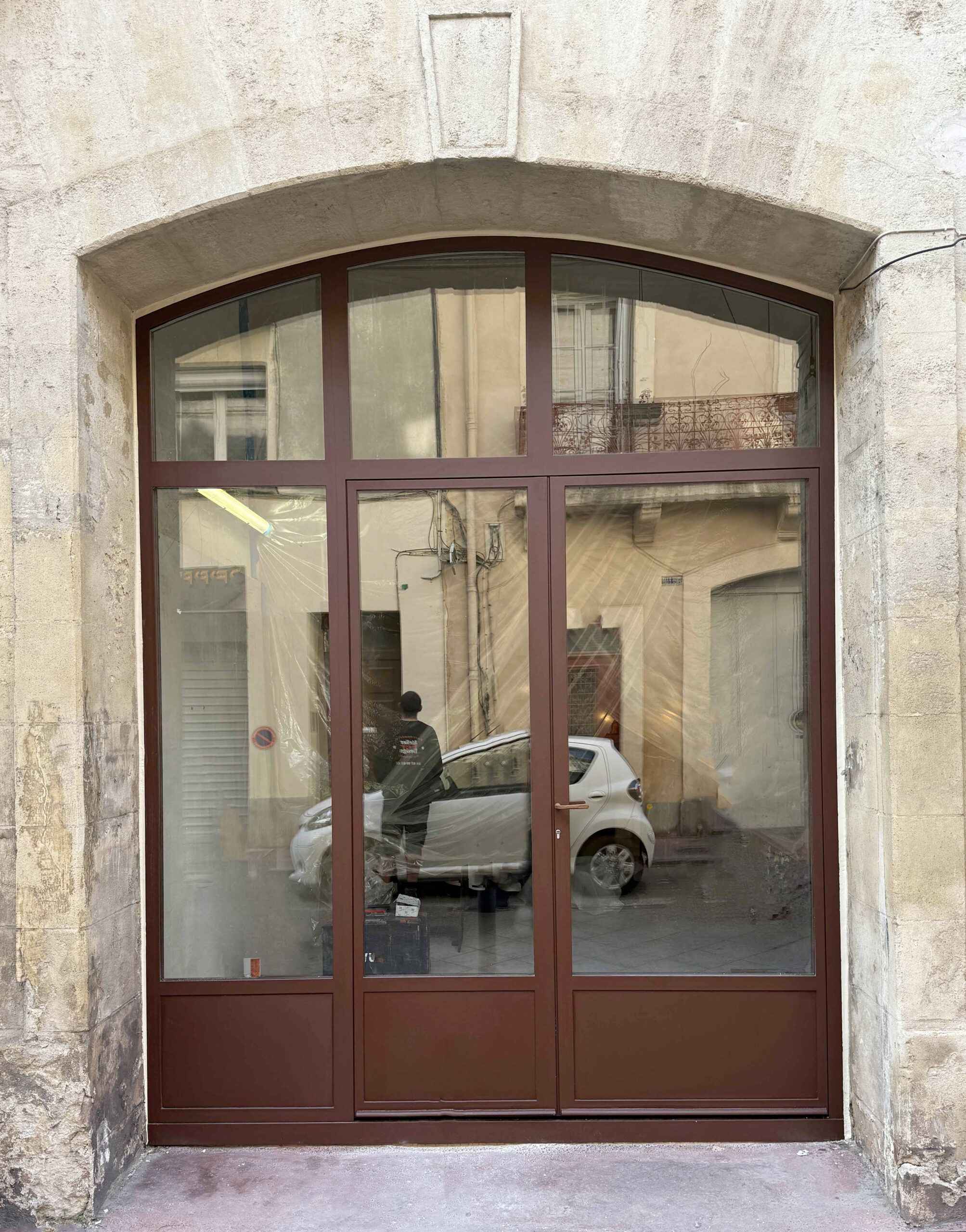 Façade de commerce avec grille métallique artisanale et porte en acier